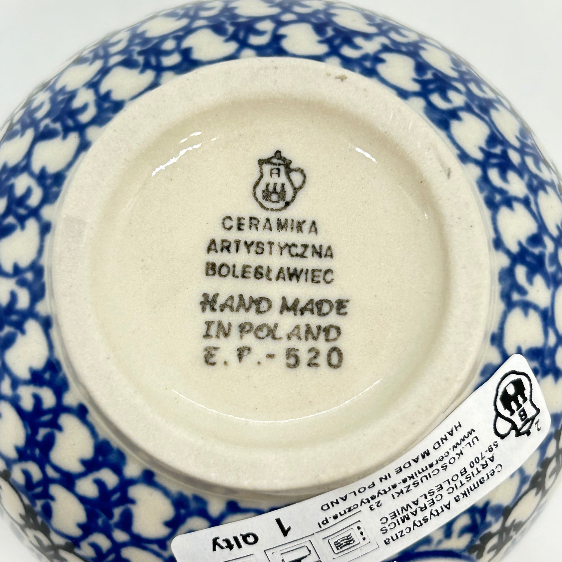 Bottom base of a Ceramika Artystyczna Polish pottery bubble mug, showing the official factory stamp, a first-quality retail sticker, and an unglazed foot ring.