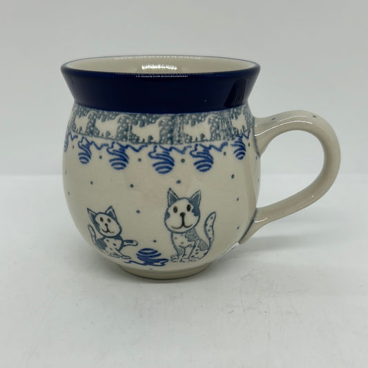 Side profile view of a Ceramika Artystyczna Polish pottery bubble mug featuring hand-painted blue cats, a ball of yarn, a cat silhouette border, and a solid blue rim.