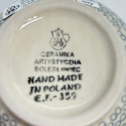 Bottom base of a Ceramika Artystyczna Polish pottery bubble mug, showing the official factory stamp, a partial retail sticker, and an unglazed foot ring.