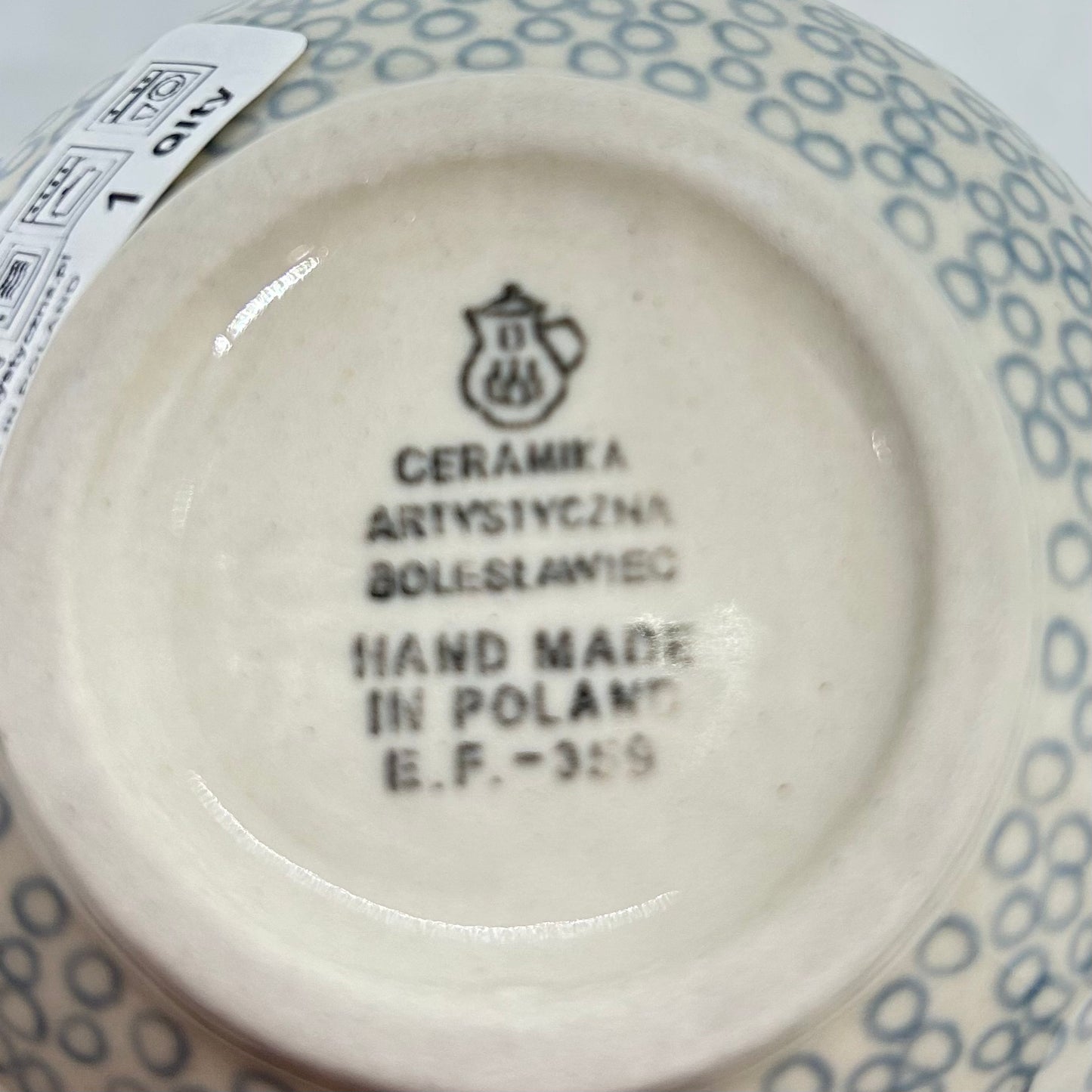 Bottom base of a Ceramika Artystyczna Polish pottery bubble mug, showing the official factory stamp, a first-quality retail sticker, and an unglazed foot ring.