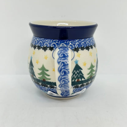 Straight-on view focusing on the patterned handle of a Ceramika Artystyczna Polish pottery bubble mug, flanked by Christmas trees, yellow stars, and complex layered borders.