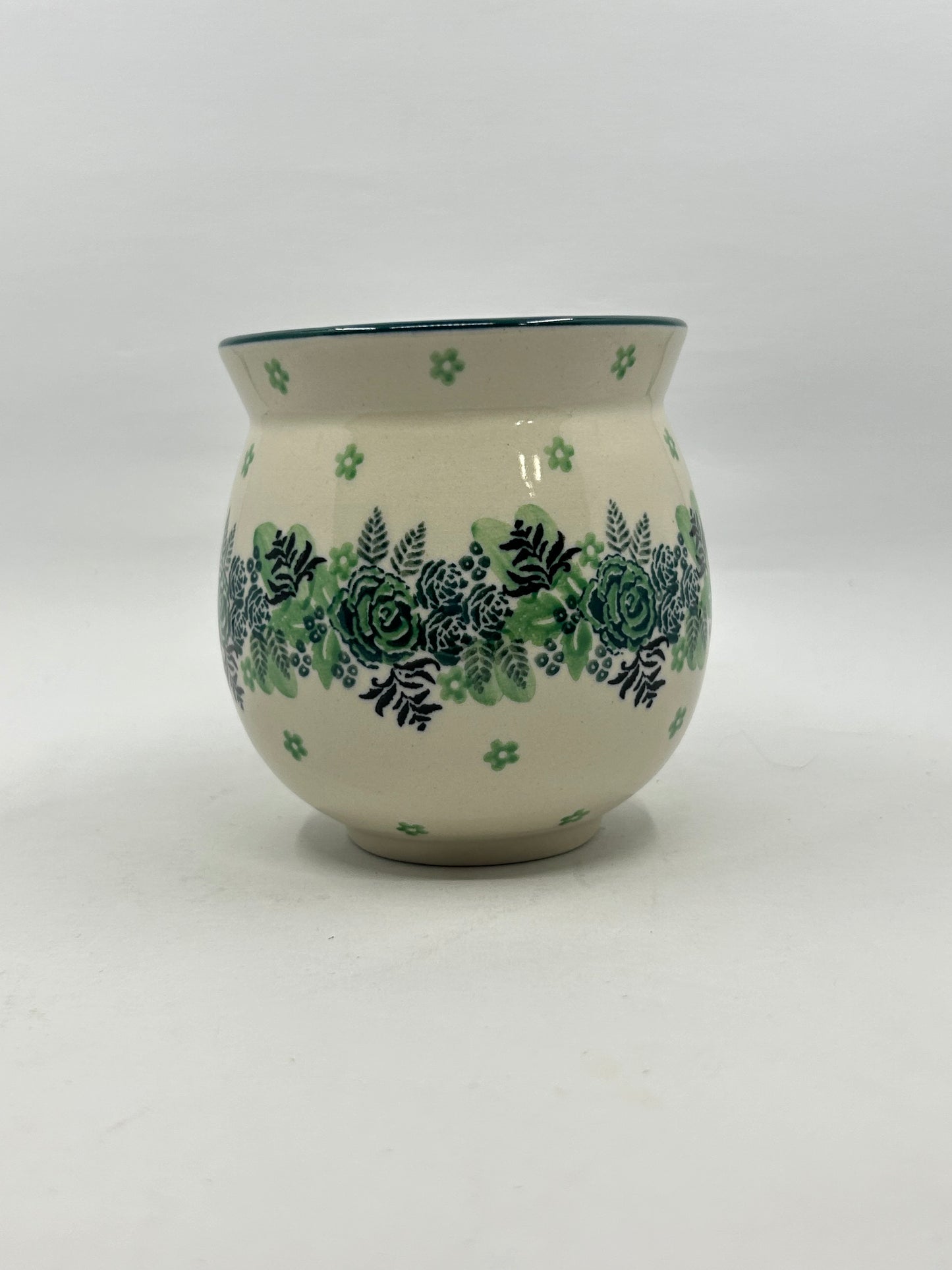 Straight-on view of the back of a Ceramika Artystyczna Polish pottery bubble mug, showing the continuous horizontal band of green roses and dark ferns on a cream background with no handle visible.