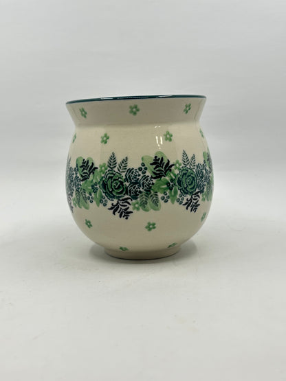 Straight-on view of the back of a Ceramika Artystyczna Polish pottery bubble mug, showing the continuous horizontal band of green roses and dark ferns on a cream background with no handle visible.