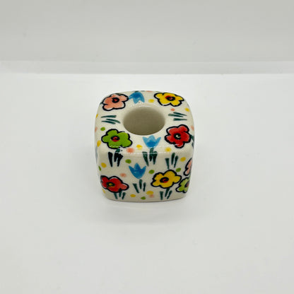 High-angle overhead view of a Ceramika Artystyczna Polish pottery cube candle holder showing the central socket and hand-painted spring flowers across the top and sides.