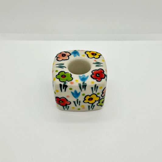 High-angle overhead view of a Ceramika Artystyczna Polish pottery cube candle holder showing the central socket and hand-painted spring flowers across the top and sides.