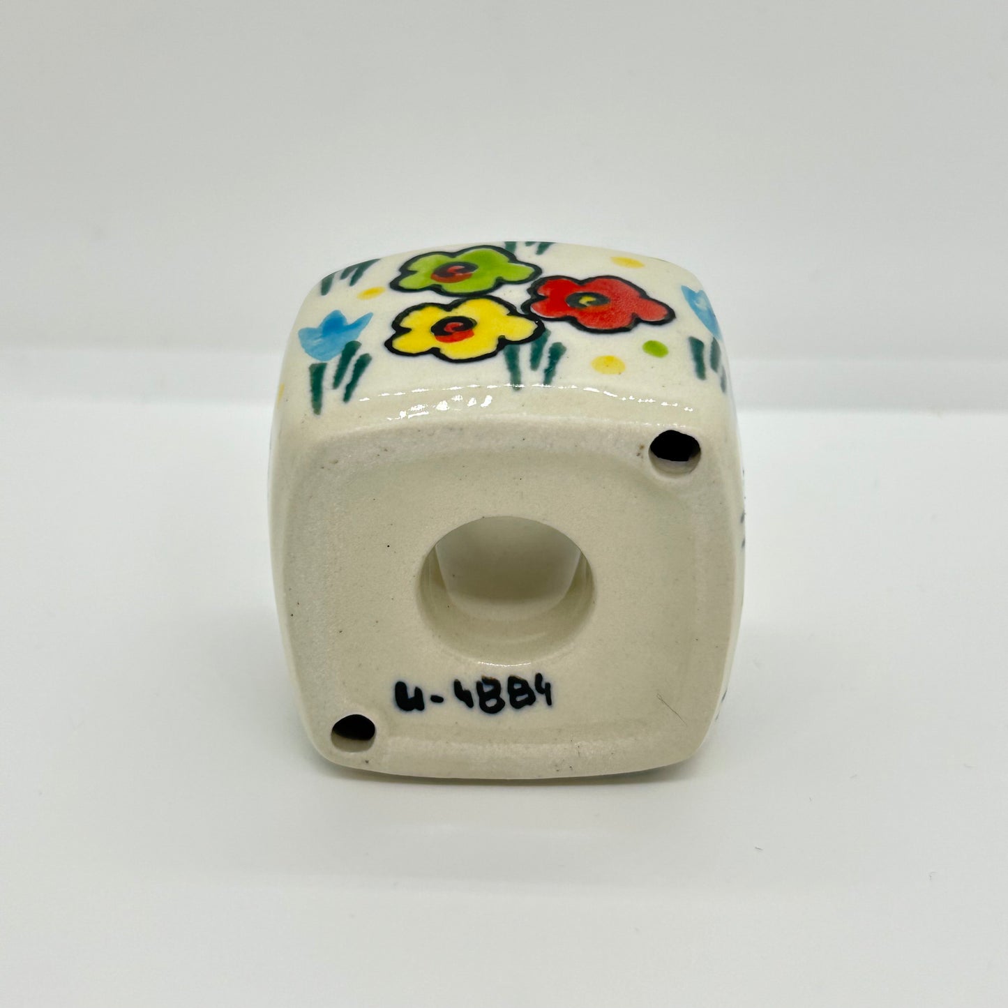 Close-up of the unglazed base of a Ceramika Artystyczna cube candle holder.
