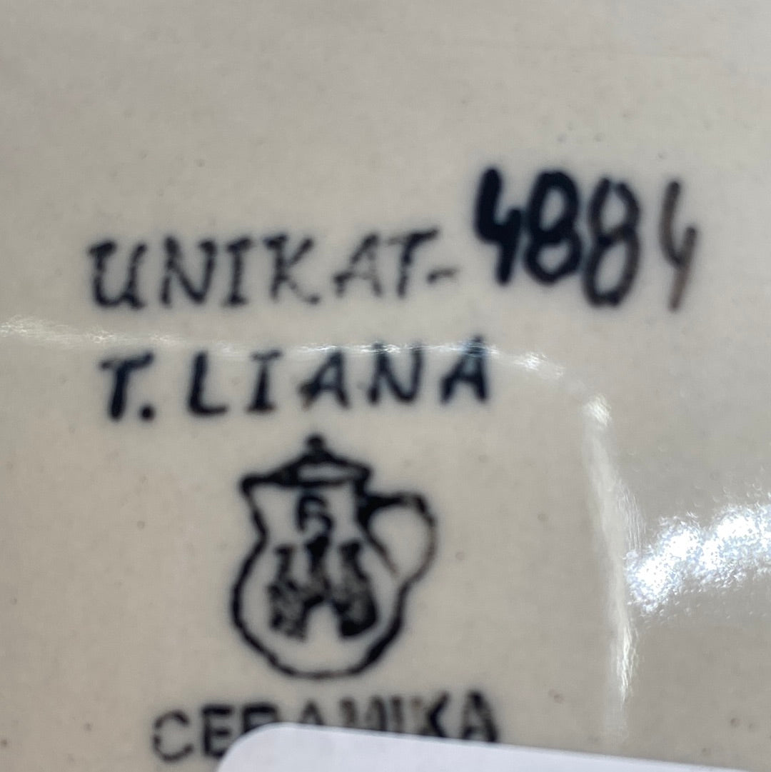 Close-up of a Ceramika Artystyczna Polish pottery base showing the UNIKAT signature stamp for T. Liana, a hand-painted 4884, the factory pitcher logo, and a partial white sticker at the bottom.