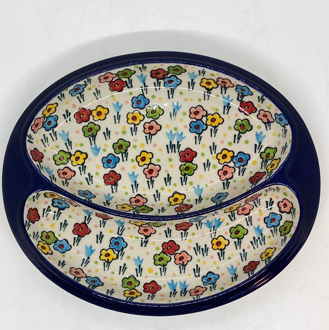 Top-down view of a Ceramika Artystyczna Polish pottery divided serving dish featuring a wide dark blue outer rim and two interior compartments decorated with hand-painted multi-colored spring flowers.