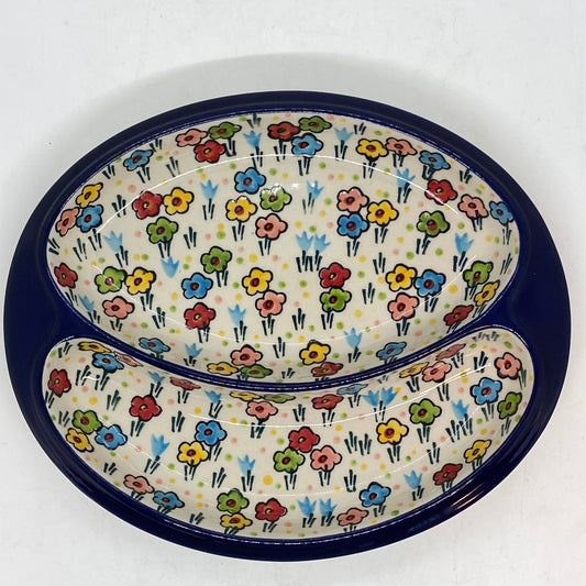 Top-down view of a Ceramika Artystyczna Polish pottery divided serving dish featuring a wide dark blue outer rim and two interior compartments decorated with hand-painted multi-colored spring flowers.