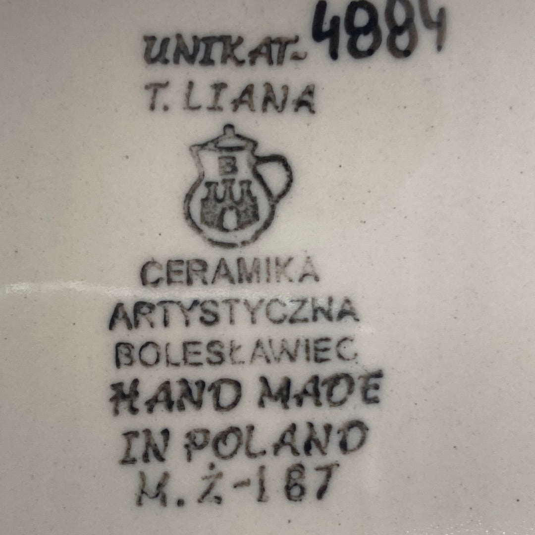 Close-up of a cream-colored Ceramika Artystyczna Polish pottery base showing the UNIKAT signature stamp for T. Liana, a hand-painted 4884, and the factory pitcher logo.