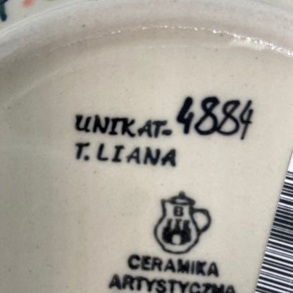 Extreme close-up of a Ceramika Artystyczna Polish pottery base showing the factory crest, a hand-painted UNIKAT 4884 designation, and the signature of master artist T. Liana