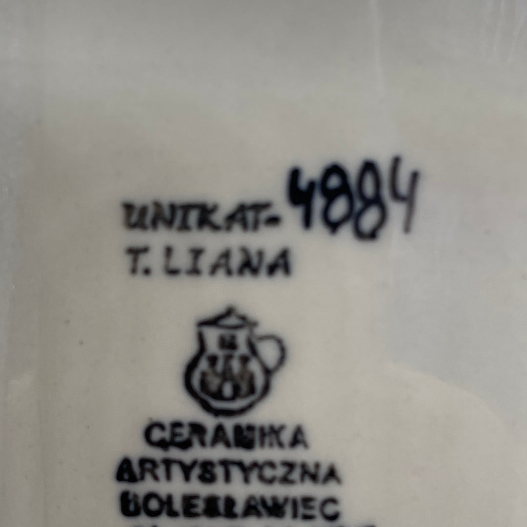 Close-up of the unglazed base of a Ceramika Artystyczna rectangular baking dish showing the T. Liana UNIKAT 4884 signature and the Bolesławiec factory stamp.