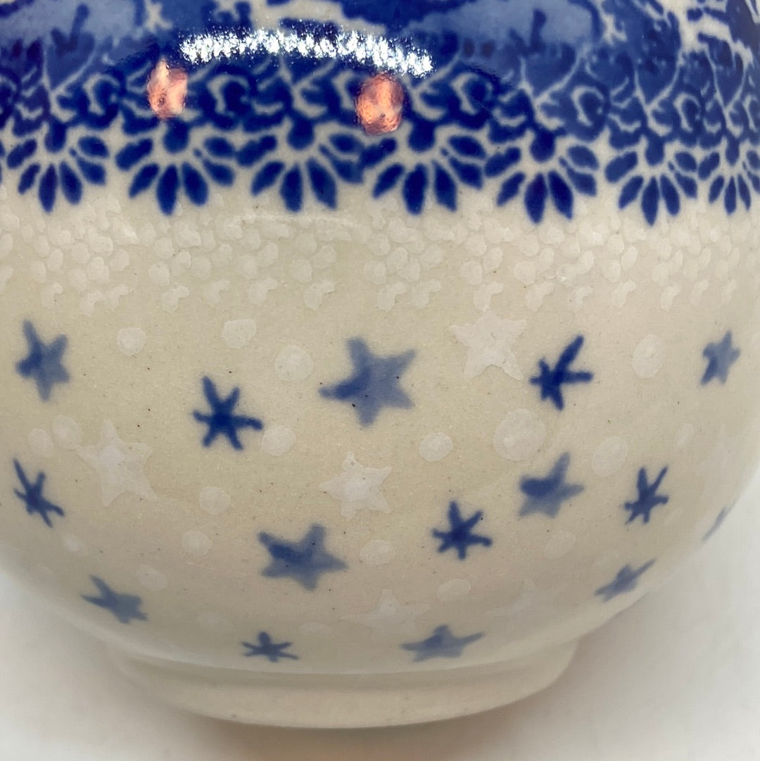 Macro close-up view of the lower half of a Ceramika Artystyczna Polish pottery bubble mug, featuring hand-stamped blue and white falling stars.